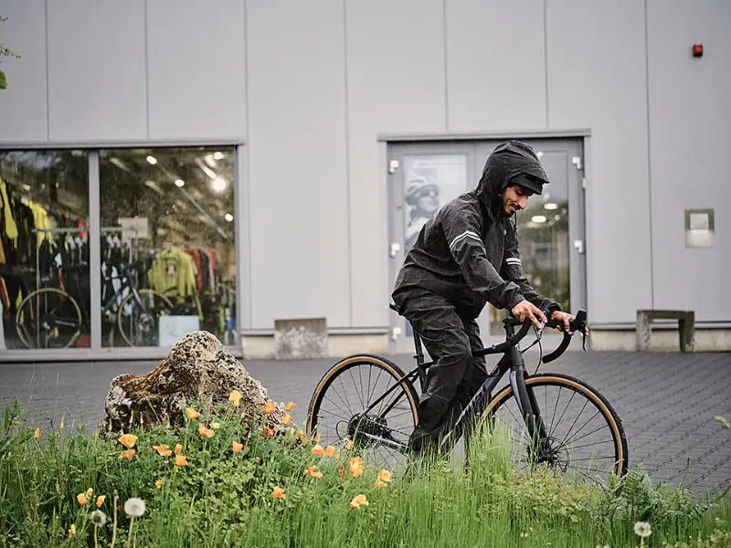 JobRadler im Regen mit Grünstreifen auf Vorplatz