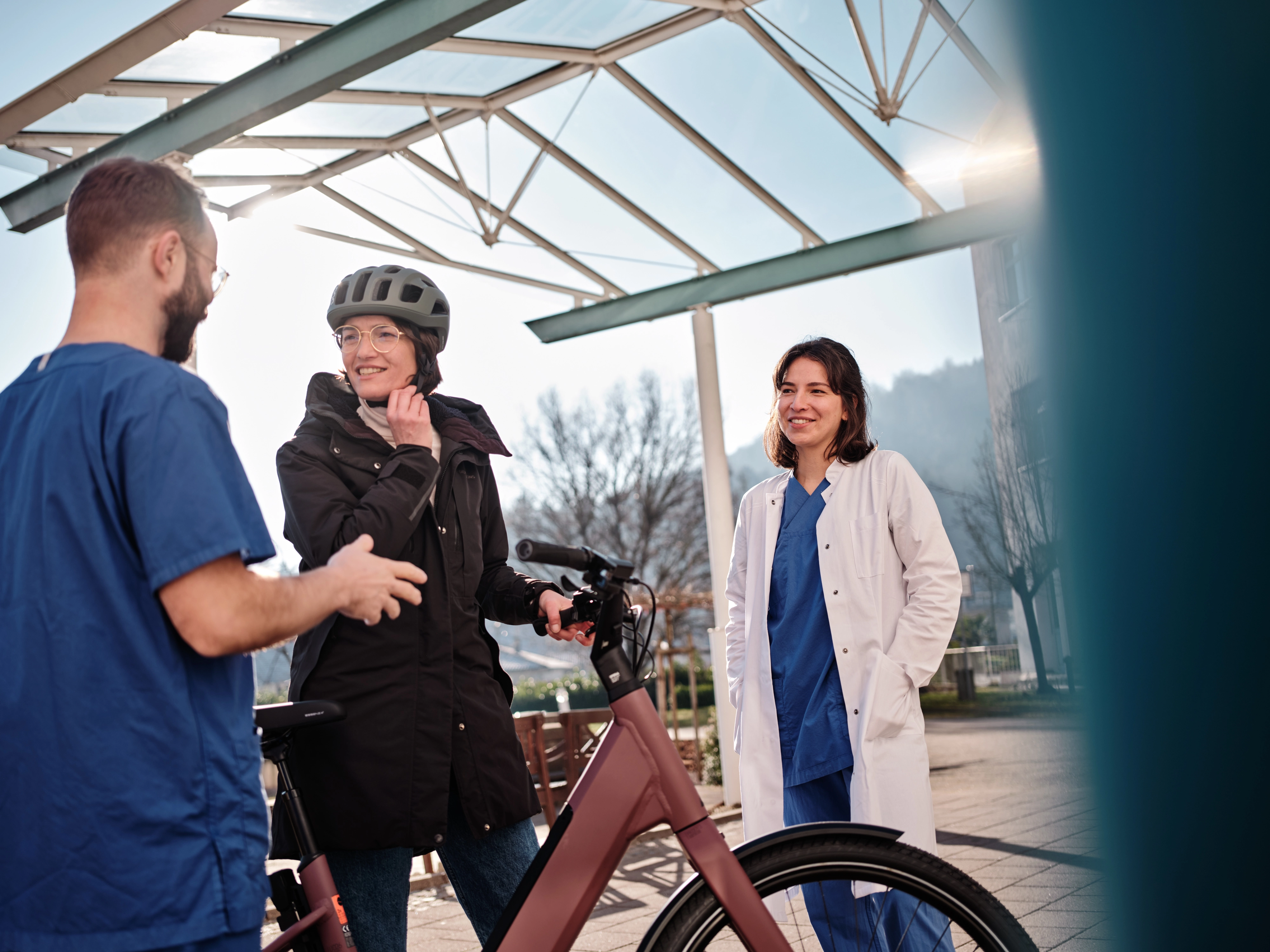 Zwei Pfleger:innen im Gespräch mit einer JobRadlerin